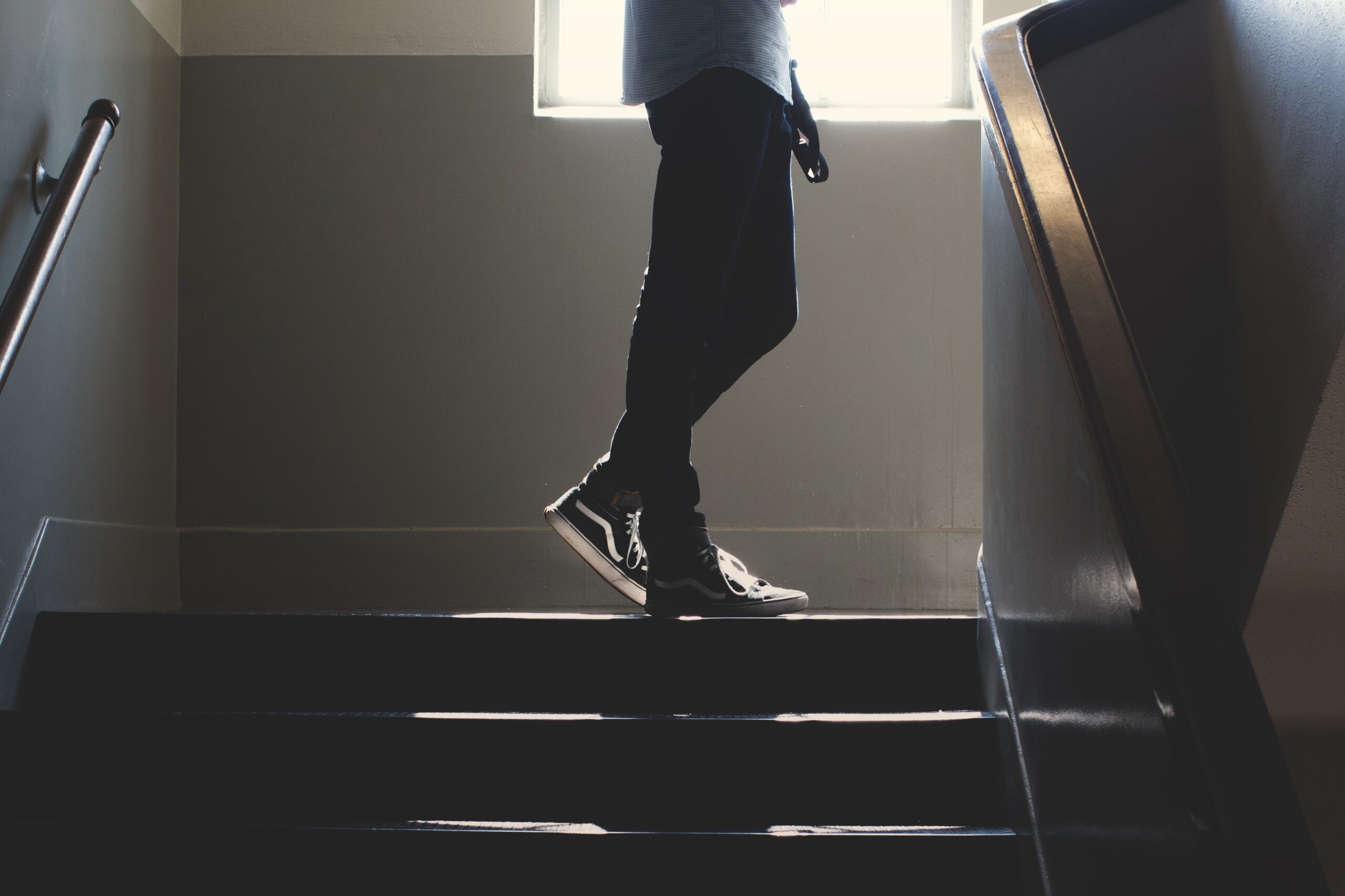 A person walks up a flight out of stairs, with only their legs in view.
