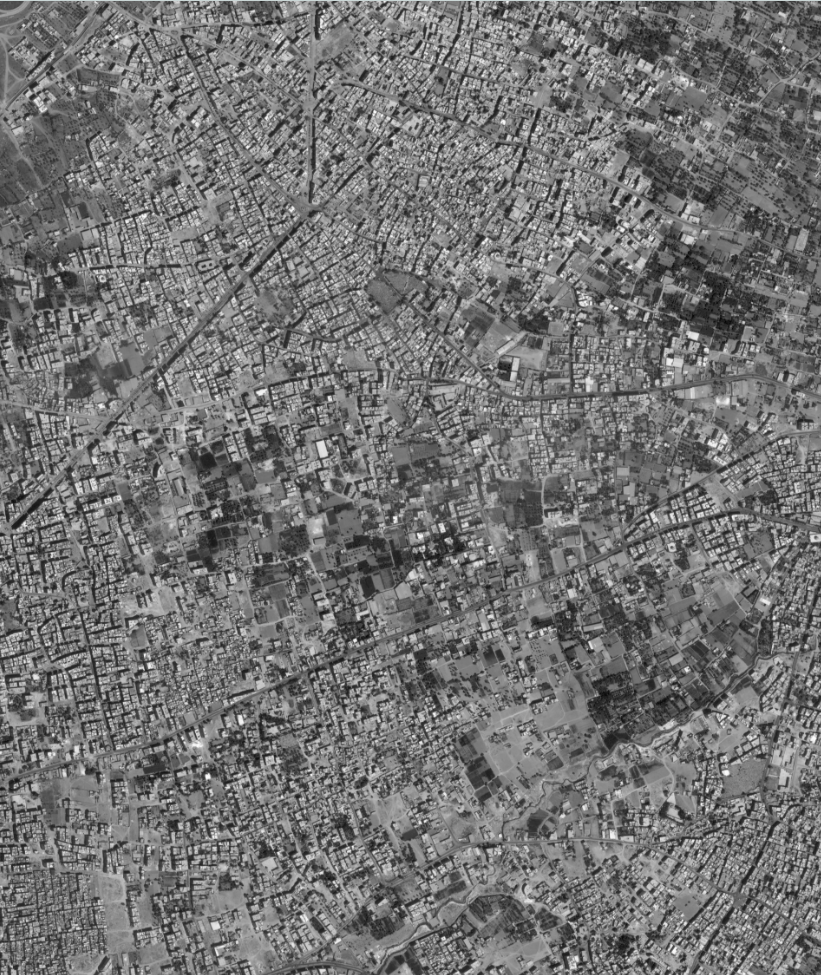 A black and white satellite image depicting human-made structures.