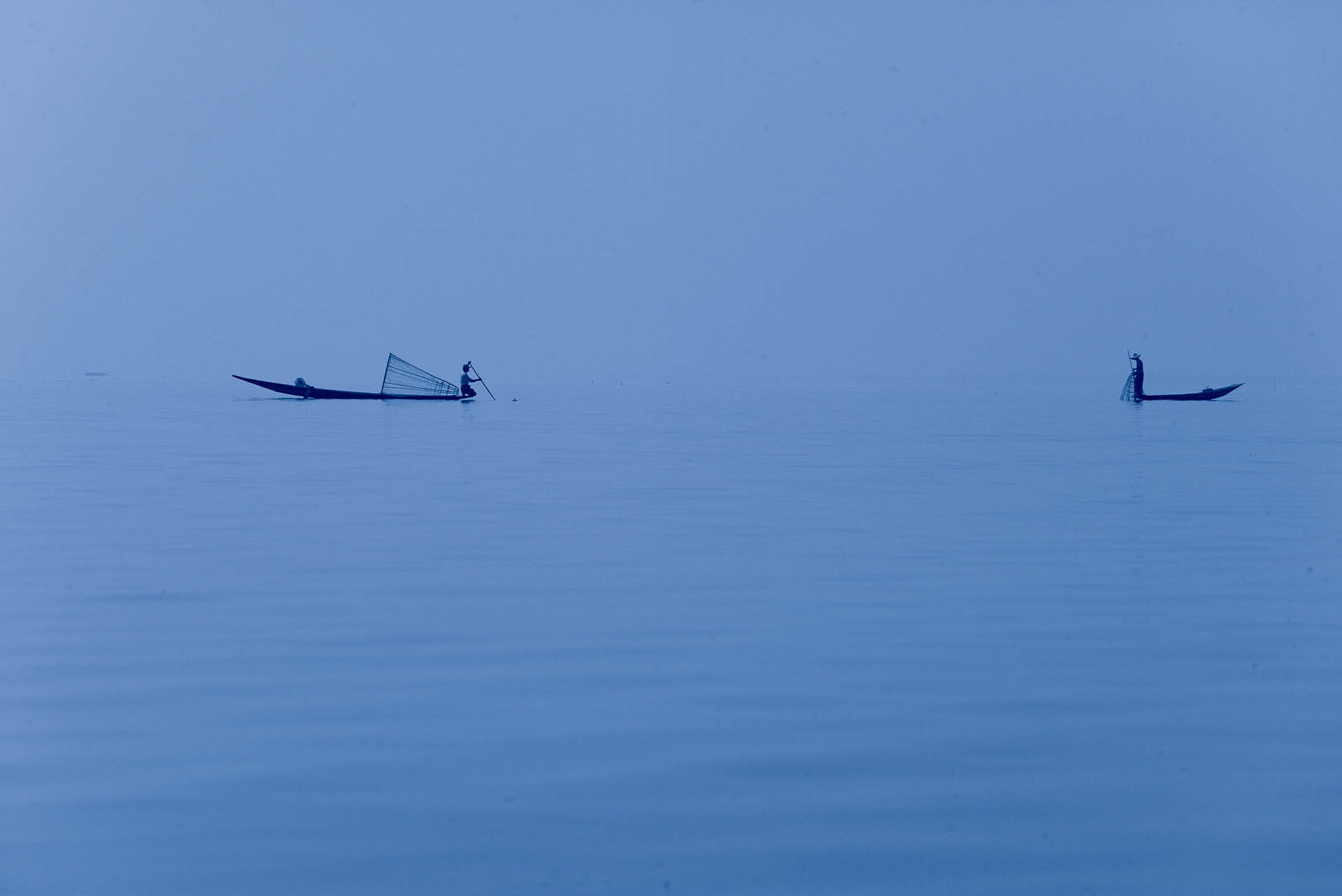 Two people in self-propelled boats glide across the water.