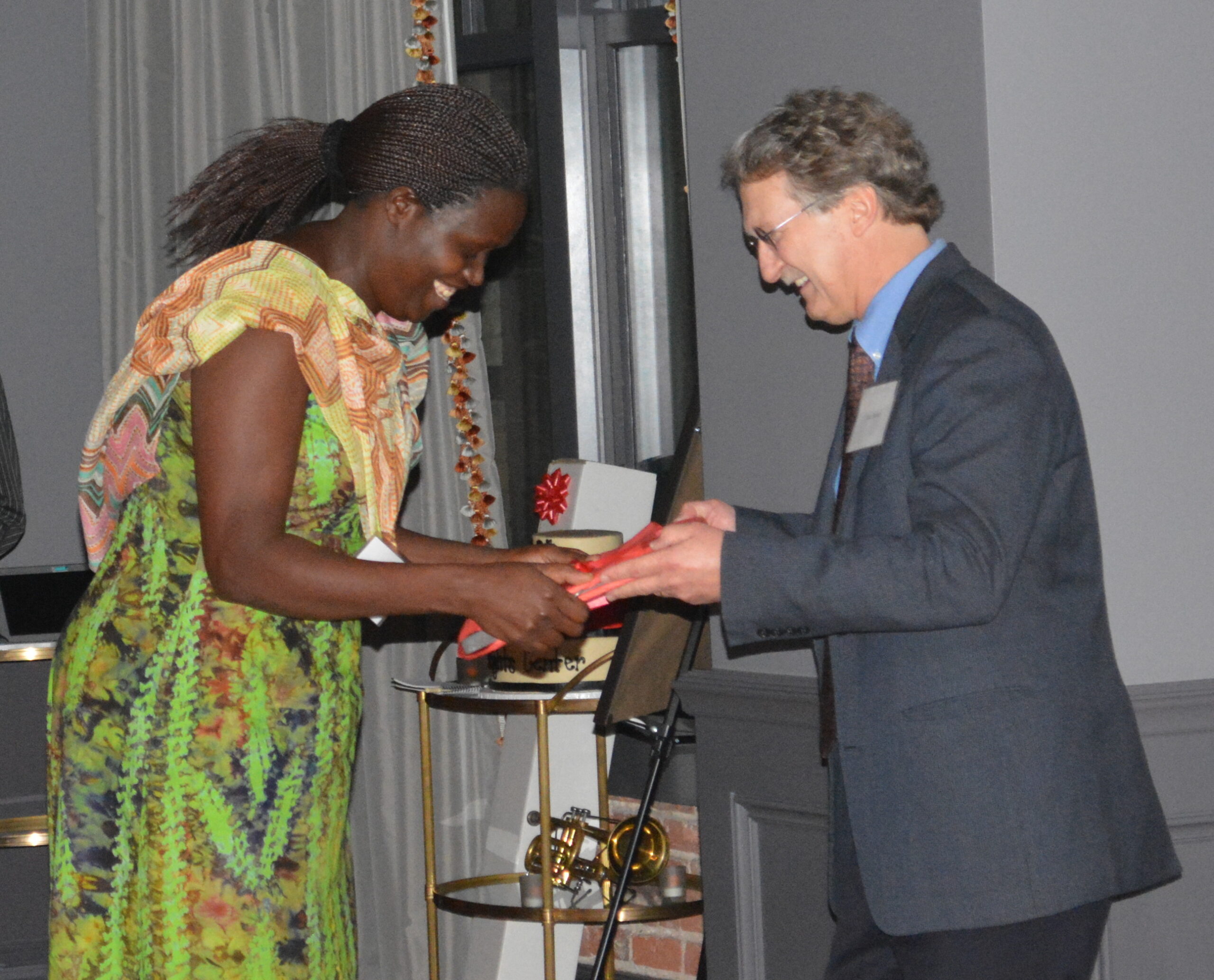A woman receives an award from a man.