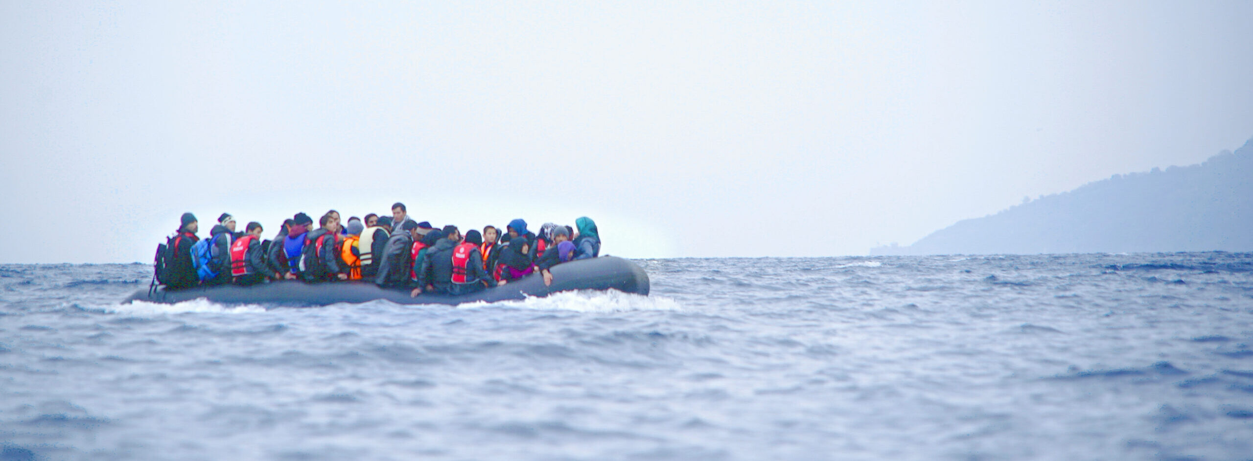 People on a small rubber boat in the ocean.