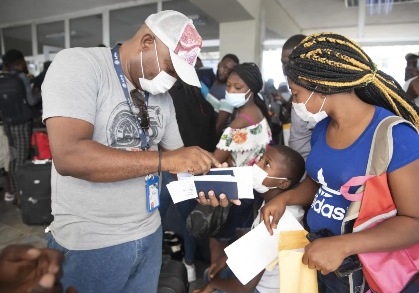 Etienne lienses checks her family's papers for a flight to Chile, at the Toussaint Louverture International Airport, in Port-au-Prince, Haiti, Sunday, Jan. 30, 2022. lienses said she was sent back to Haiti from Texas on Dec. 14 and talked to the AP before flying to Santiago with her three children on a Jan. 30 charter flight on SKY. 