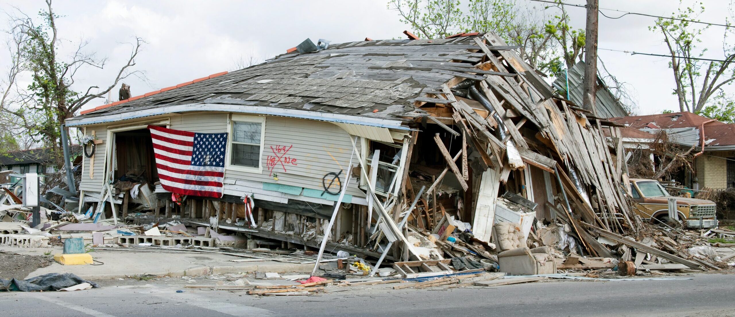 A destroyed home displays an American flag.