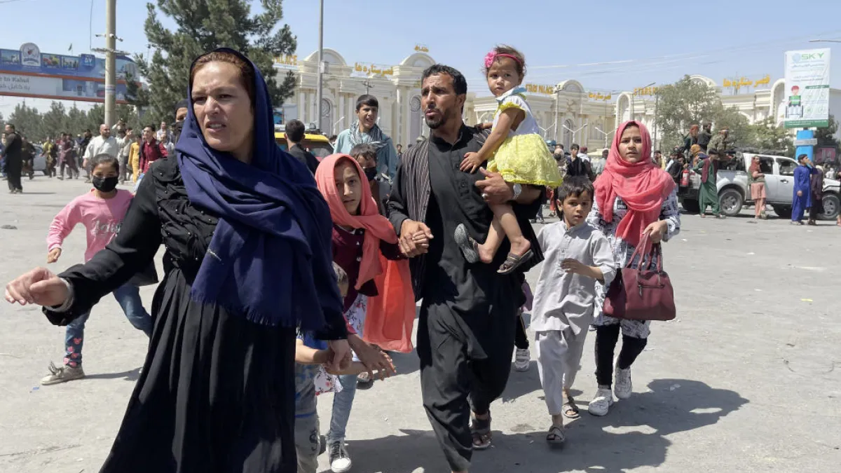 KABUL, AFGHANISTAN-AUGUST 16: An Afghan family rushes to the Hamid Karzai International Airport as they flee the Afghan capital of Kabul, Afghanistan, on August 16, 2021. (Photo by Haroon Sabawoon/Anadolu Agency via Getty Images).