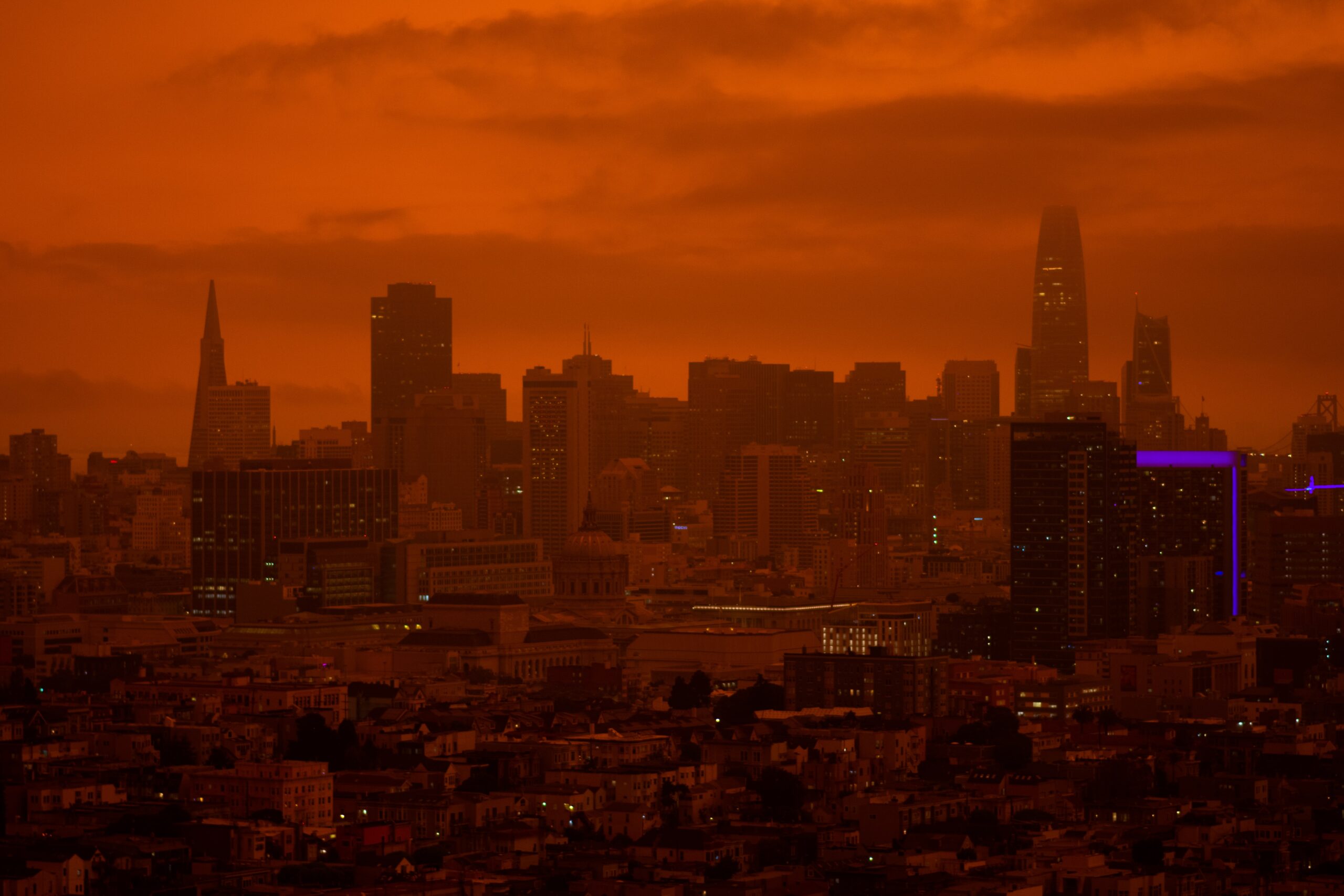 The San Francisco skyline is engulfed in an orange wildfire haze.