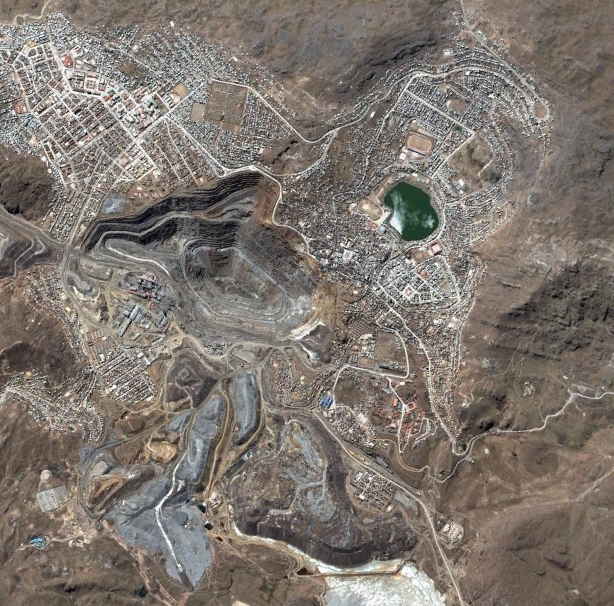 An aerial image of a town with a large manmade pit in the center.