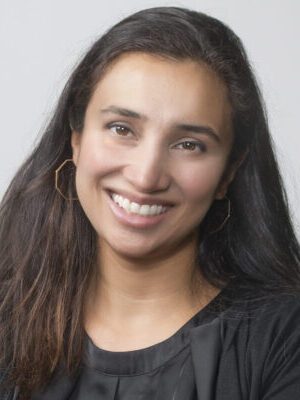 A woman with brown hair smiles at the camera.