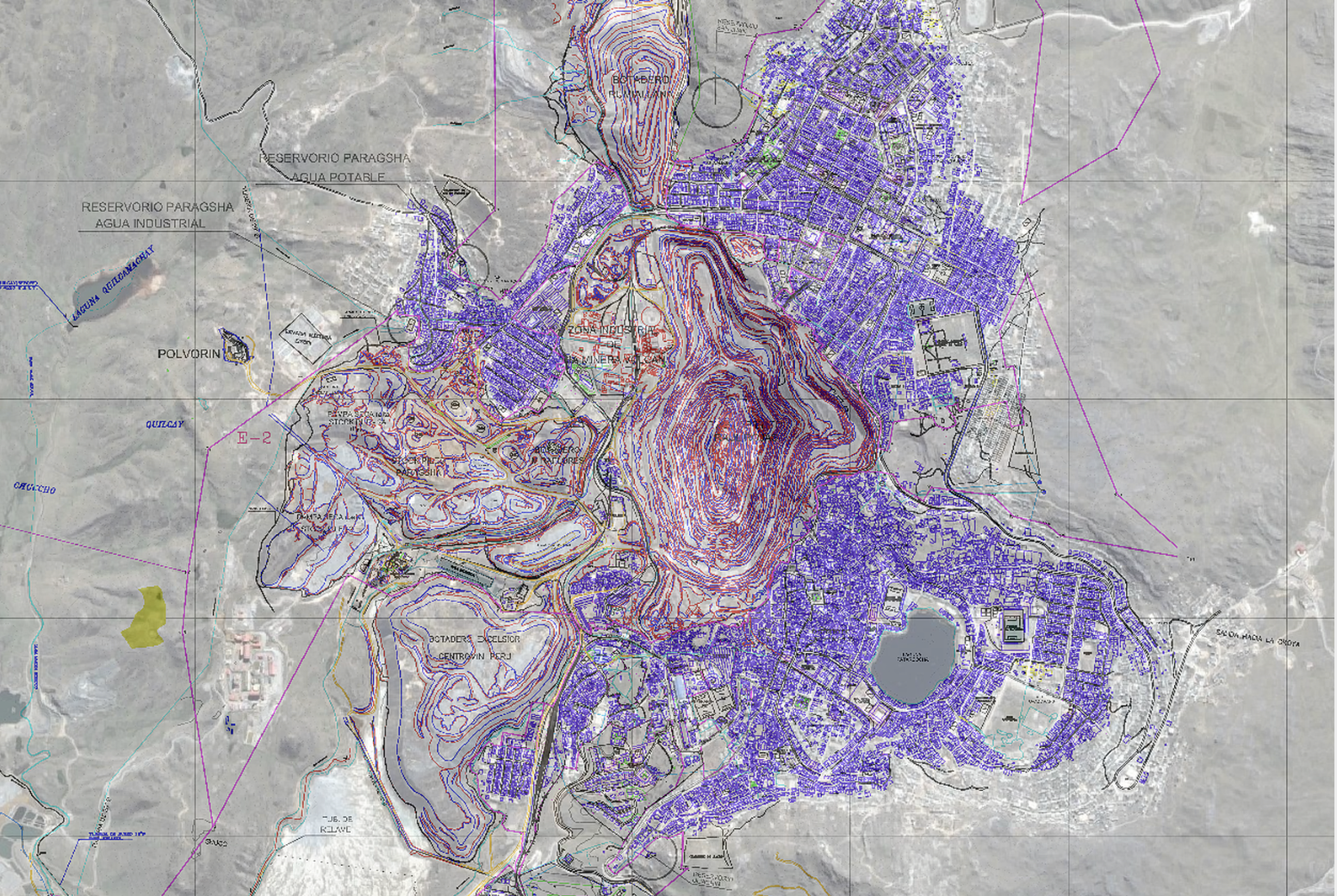 An aerial image of a town with a large manmade pit in the center. The image has many areas highlighted in purple.