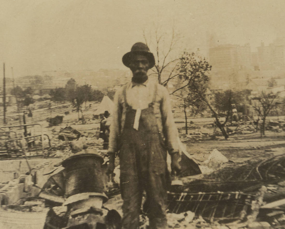 A man stands in the midst of rubble.