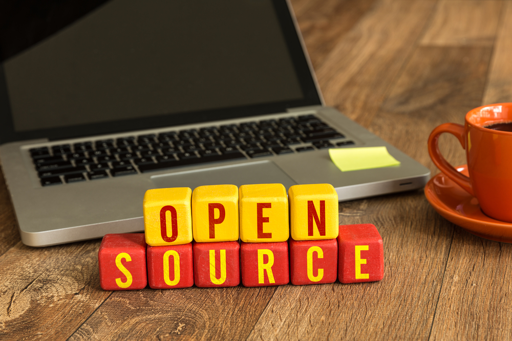 a laptop and open source spelling in yellow and red cubes