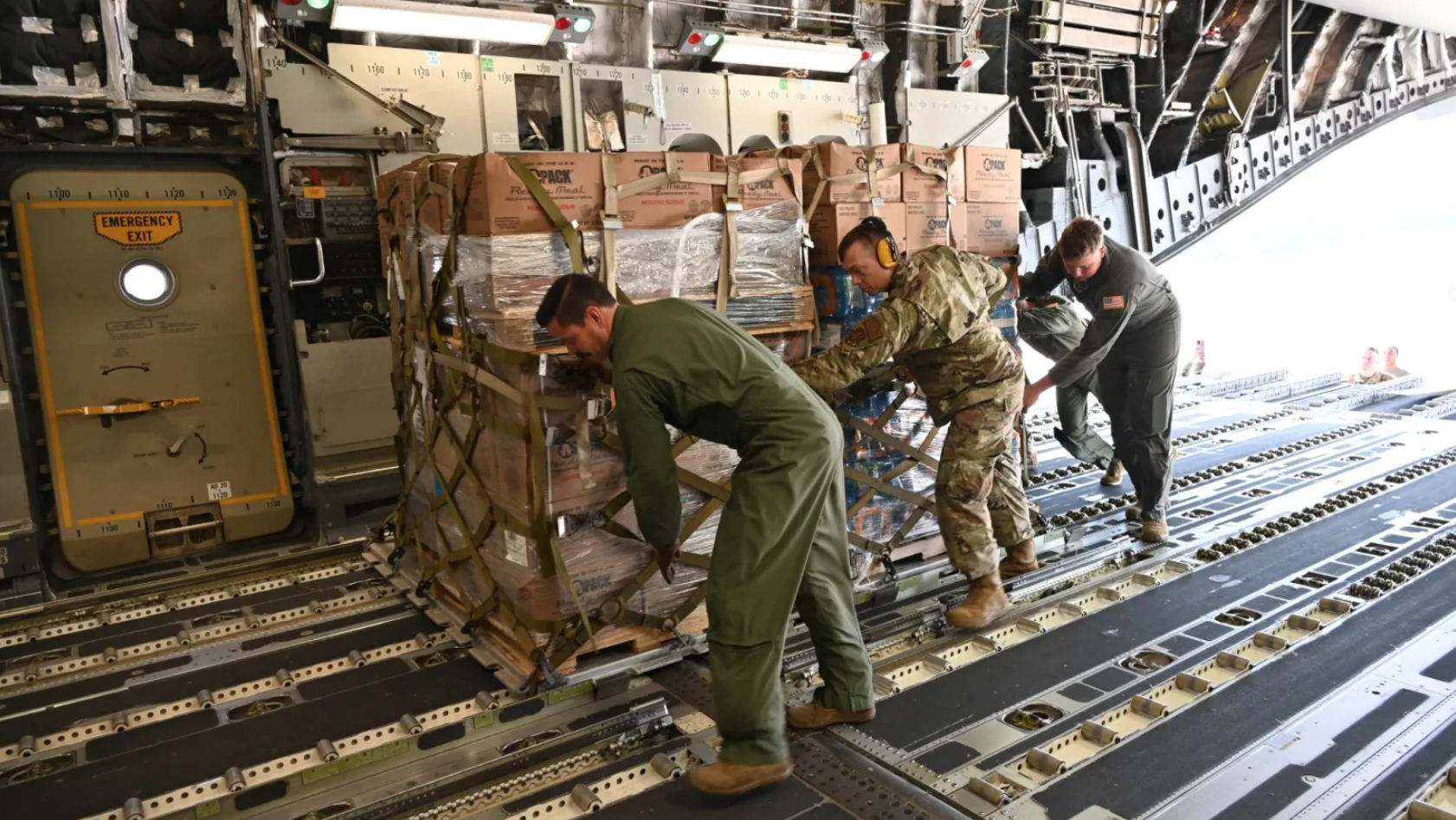 Airmen loading cargo pallets of food and humanitarian aid